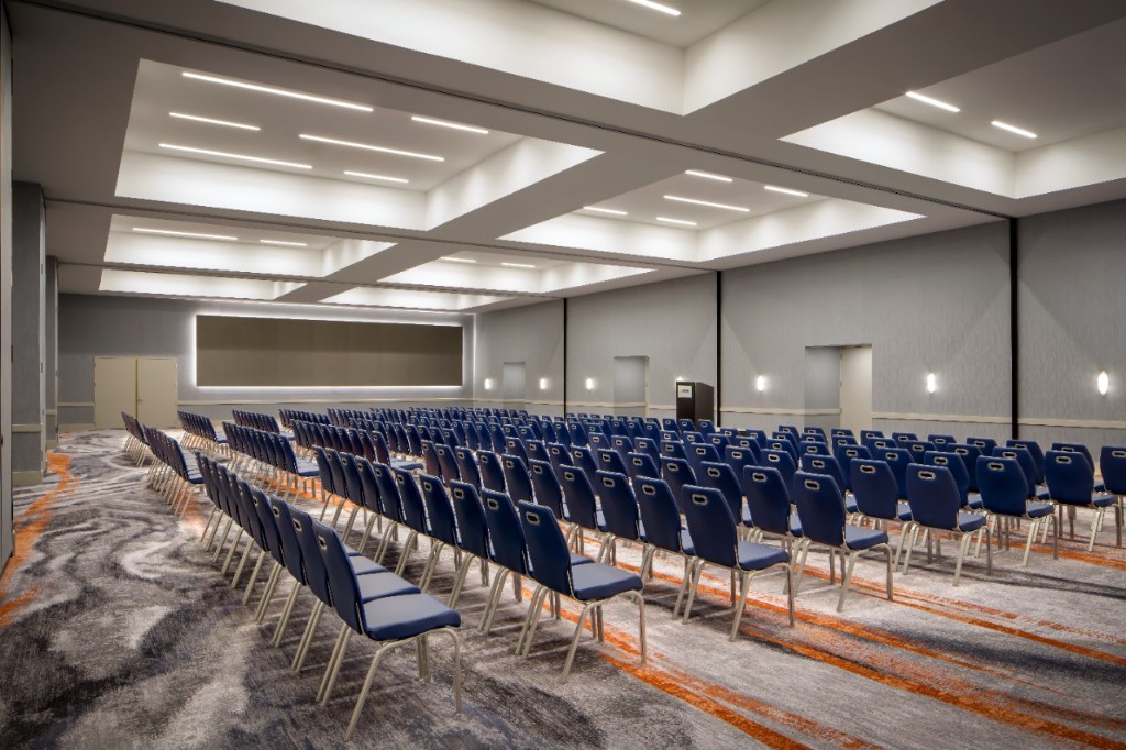 Ballroom set with rows of chairs, modern ceiling lighting, and patterned carpet